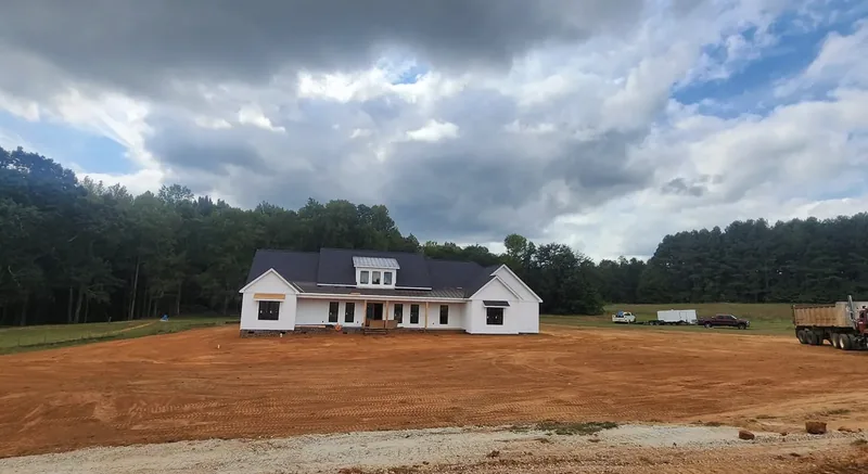 A wide lot graded flat in front of a newly built farmhouse by Little Acres Grading