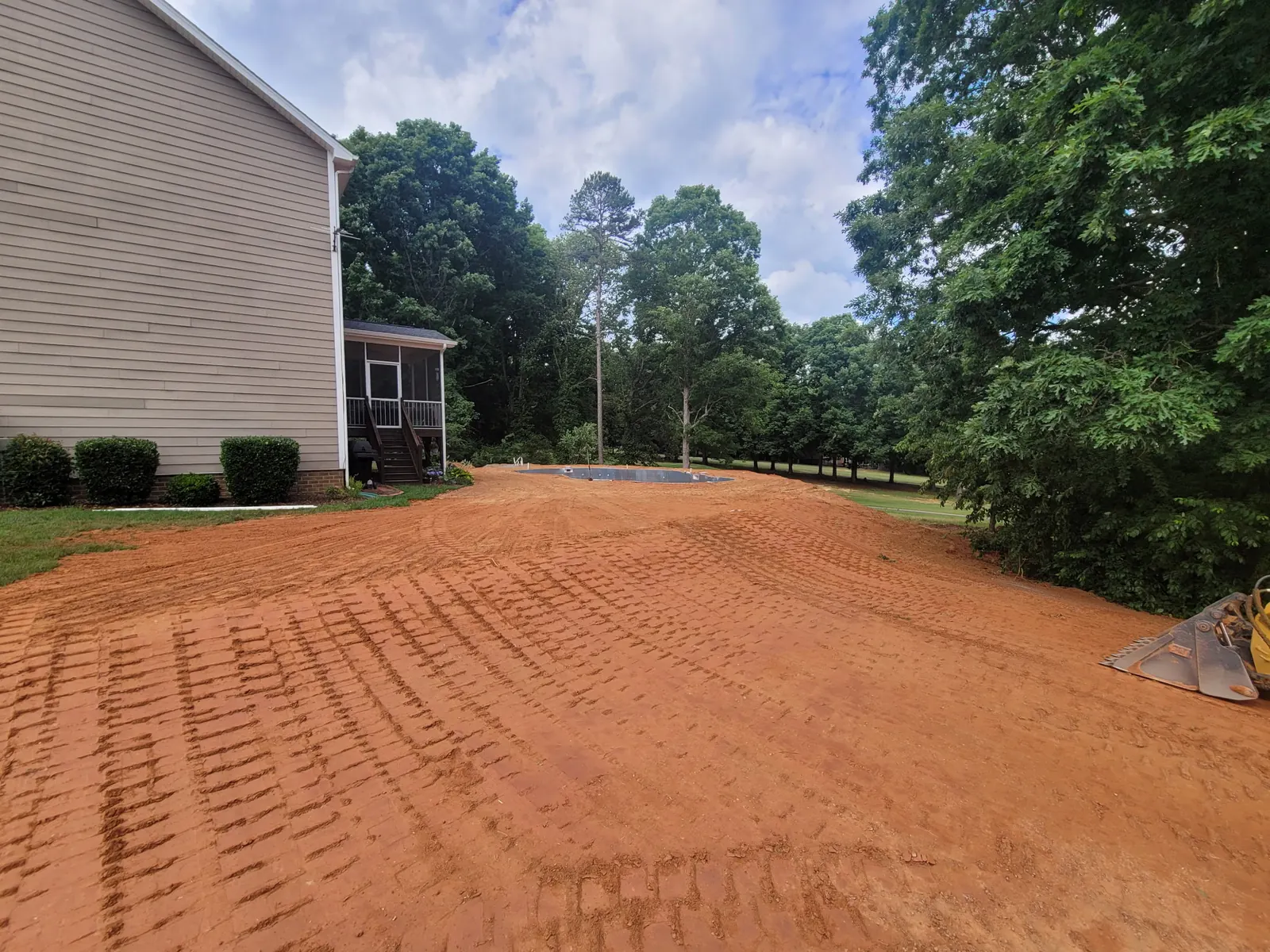A back yard regraded and smoothed for seeding beside a two-story home — Little Acres Grading