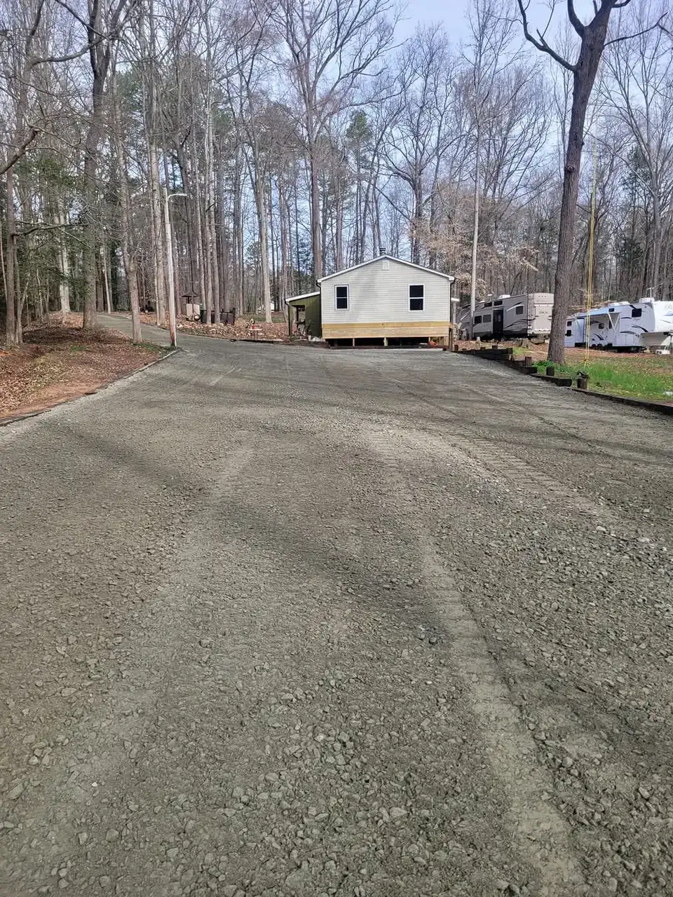 A new gravel drive graded and stoned up to a home set back in the trees — Little Acres Grading, Morganton NC