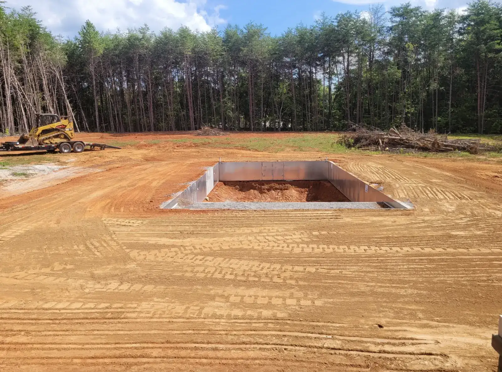 An inground pool excavated and walled in on an open cleared field — Little Acres Grading