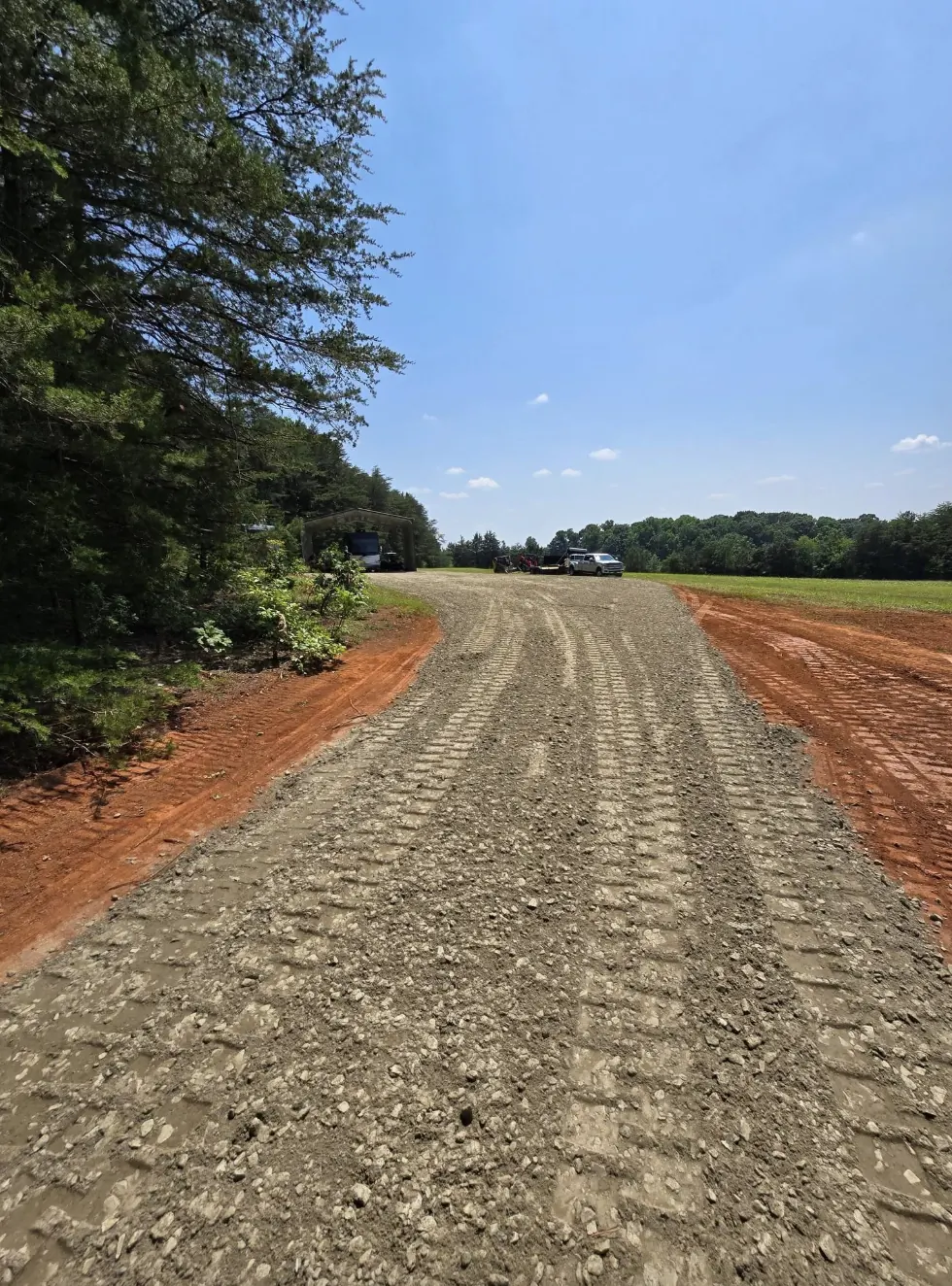 A new gravel driveway cut and stoned through a stand of pines — Little Acres Grading