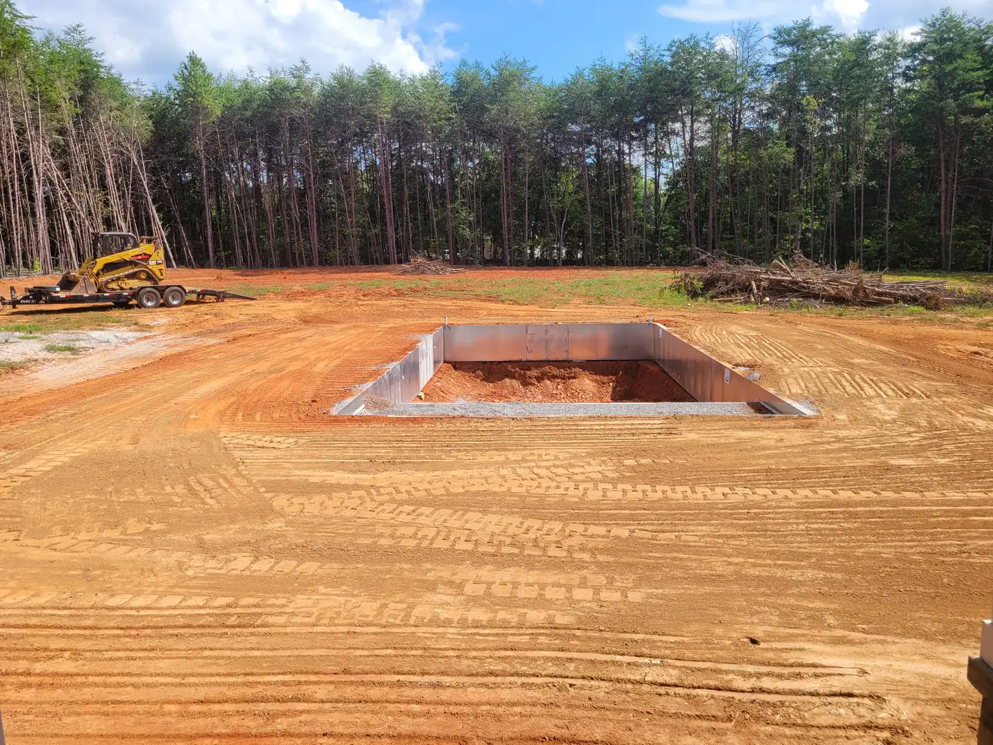 A pool excavated and shaped on a cleared field with the walls set — Little Acres Grading