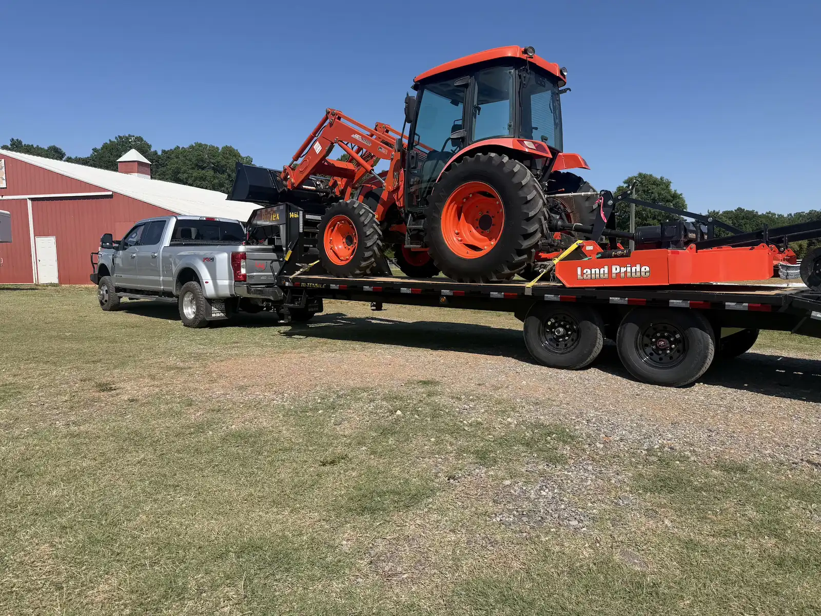 A tractor and rotary cutter loaded out and ready for a brush hogging job — Little Acres Grading